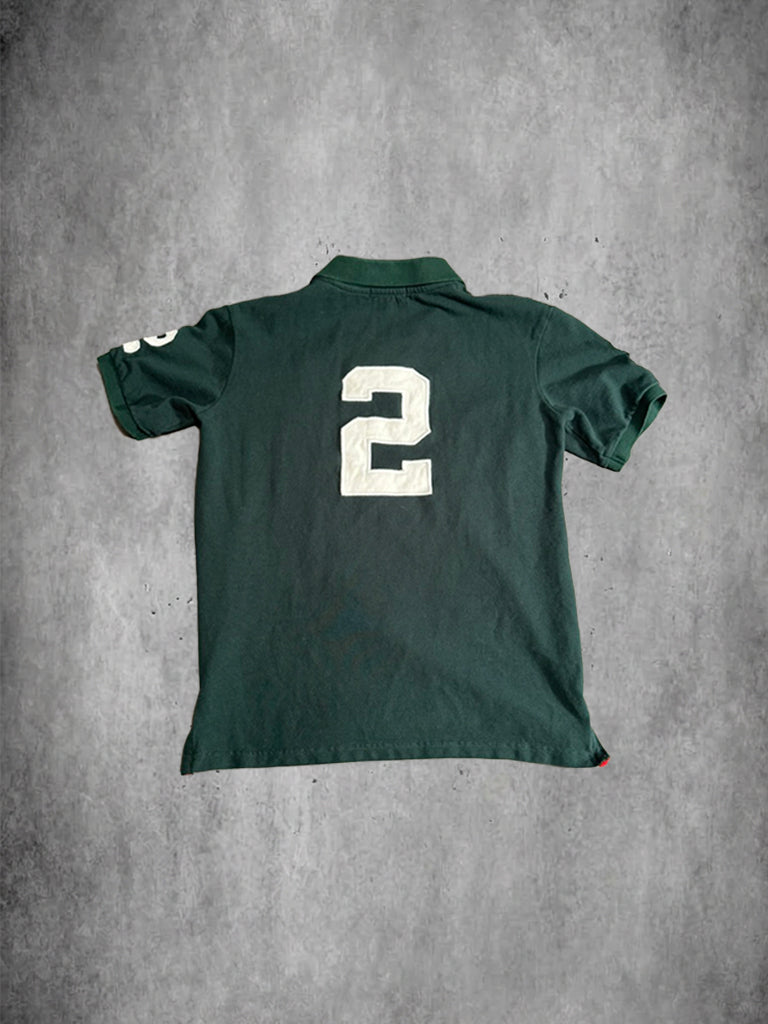 Green polo shirt with number 2 on the back against a gray concrete background