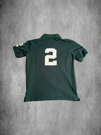 Green polo shirt with number 2 on the back against a gray concrete background