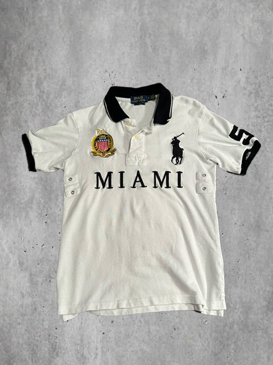 White polo shirt with 'Miami' text and logo on a gray textured background