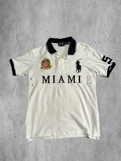 White polo shirt with 'Miami' text and logo on a gray textured background